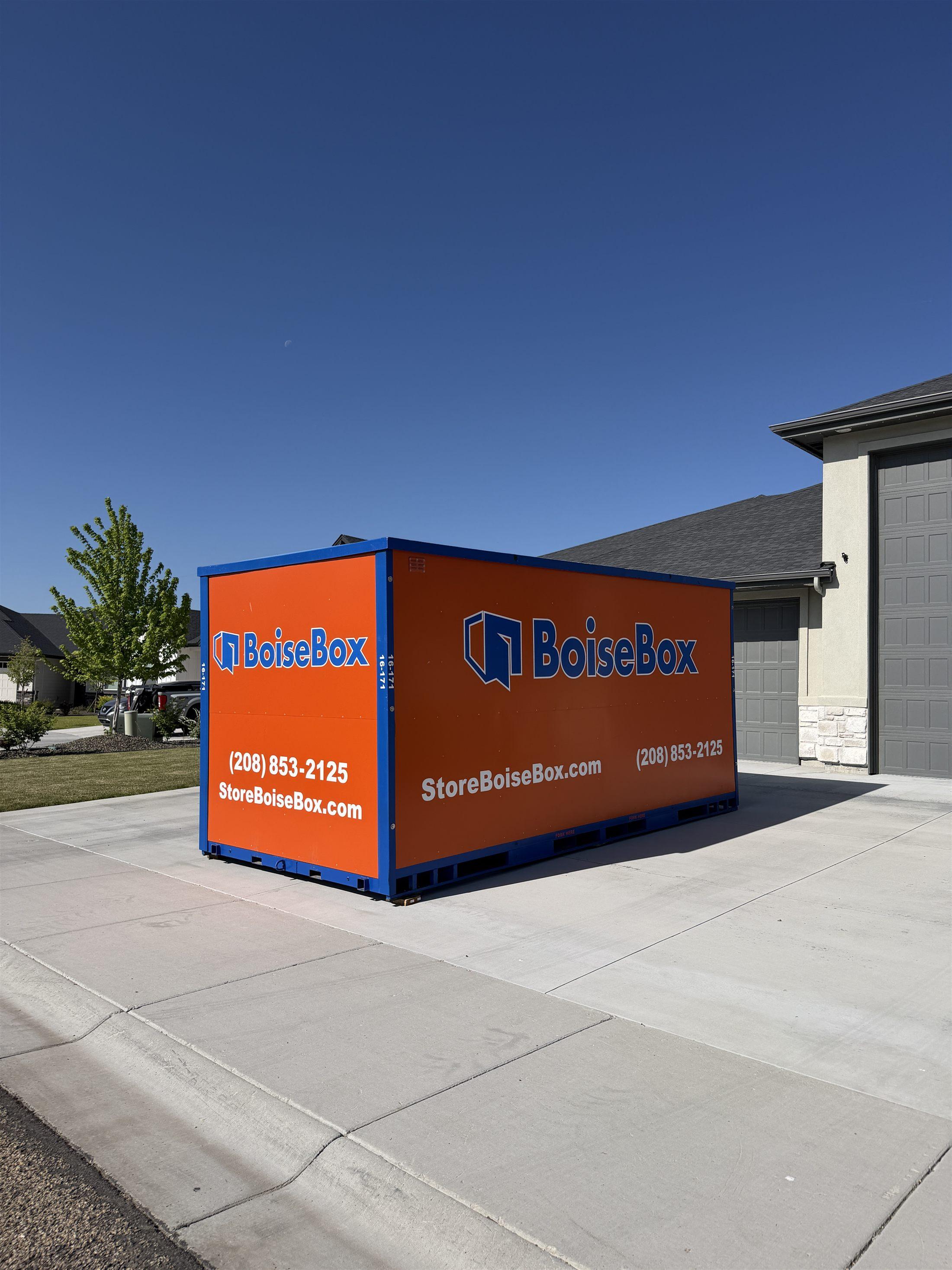 Customer carrying boxes beside an open BoiseBox container